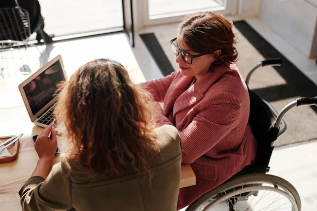 Two people discussing information together at home, illustrating ndis support services in brisbane.