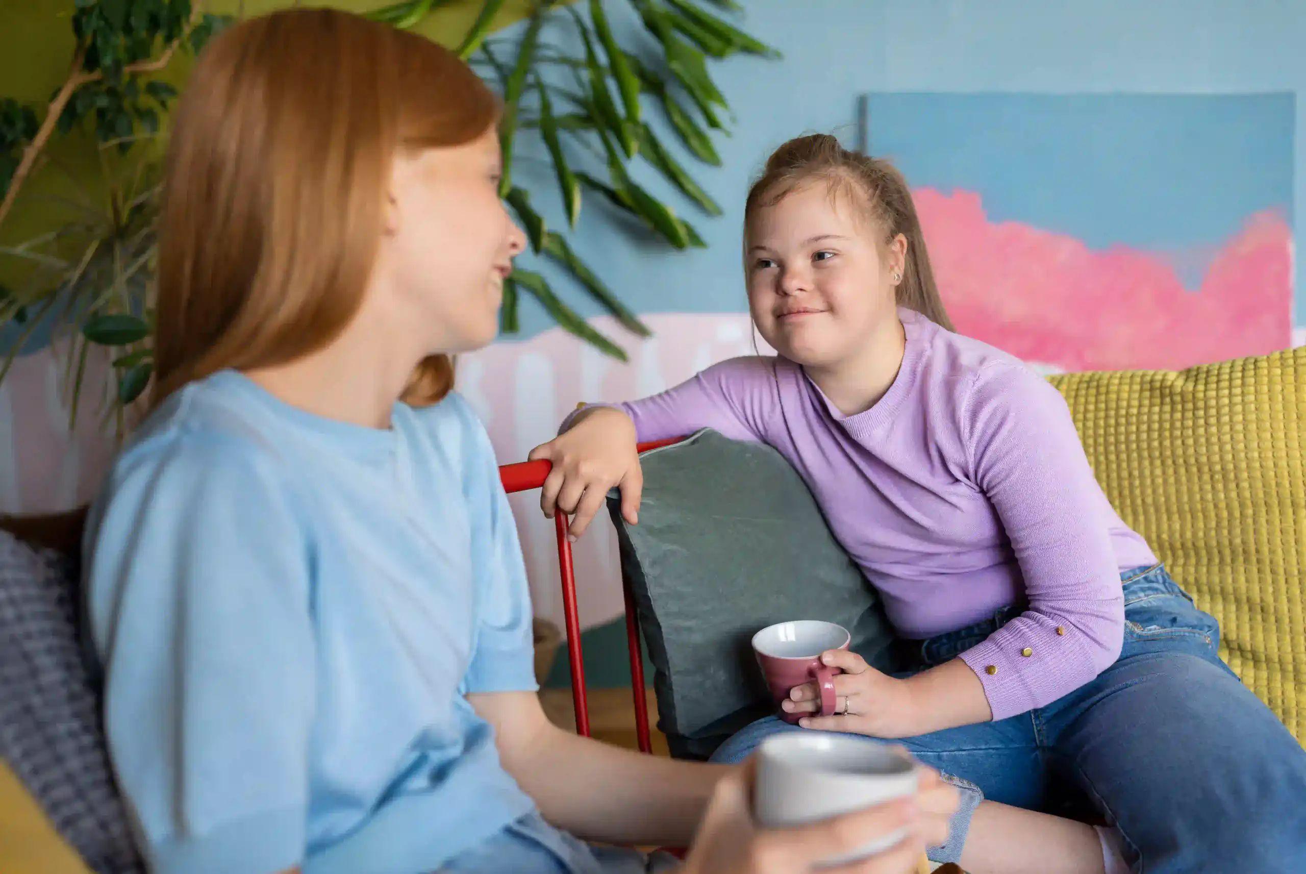 Two people talking together in a living room, illustrating disability support services on the fraser coast.