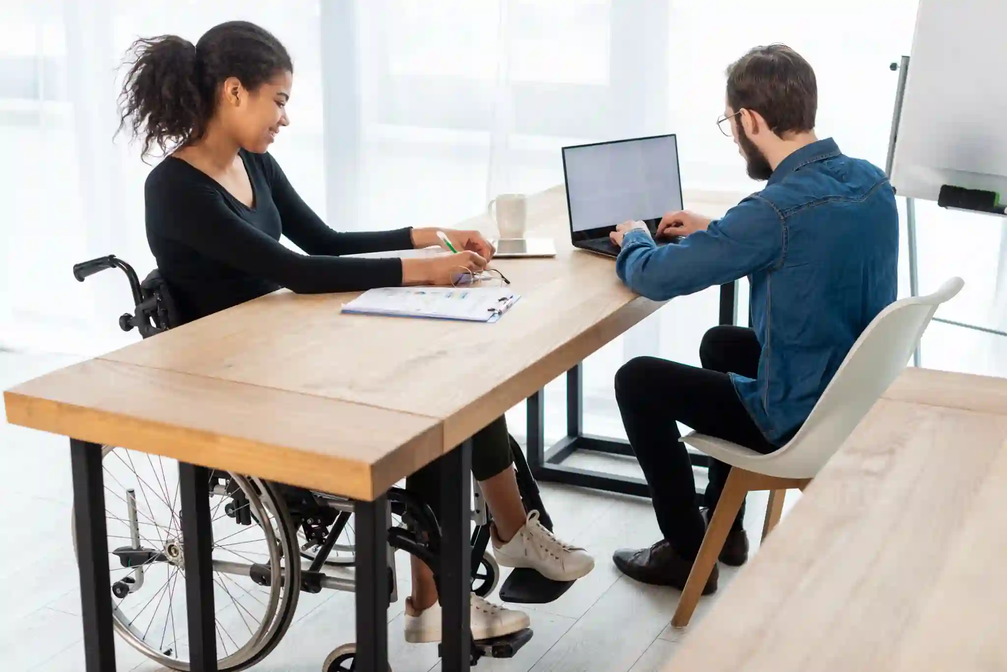 Two people discussing paperwork at a desk, illustrating support coordination in toowoomba.